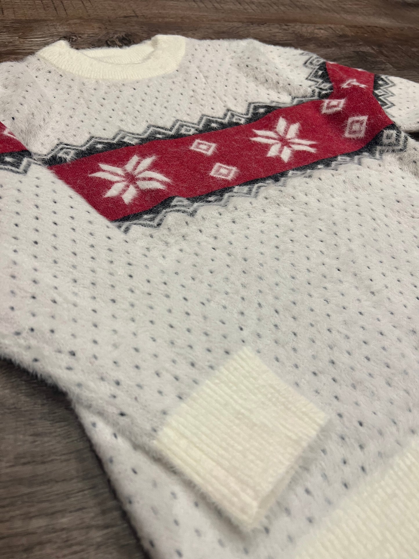 Girls ivory crew neck sweater with red and black winter detail.